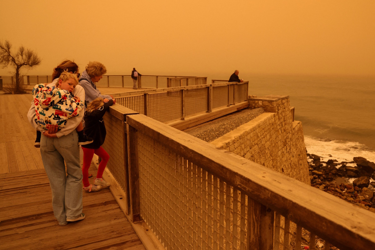 People look at the horizon turned yellow, caused by sand dust from the Sahara, due to strong southern winds, in Heraklion, Crete island, Greece, April 1, 2026. REUTERS