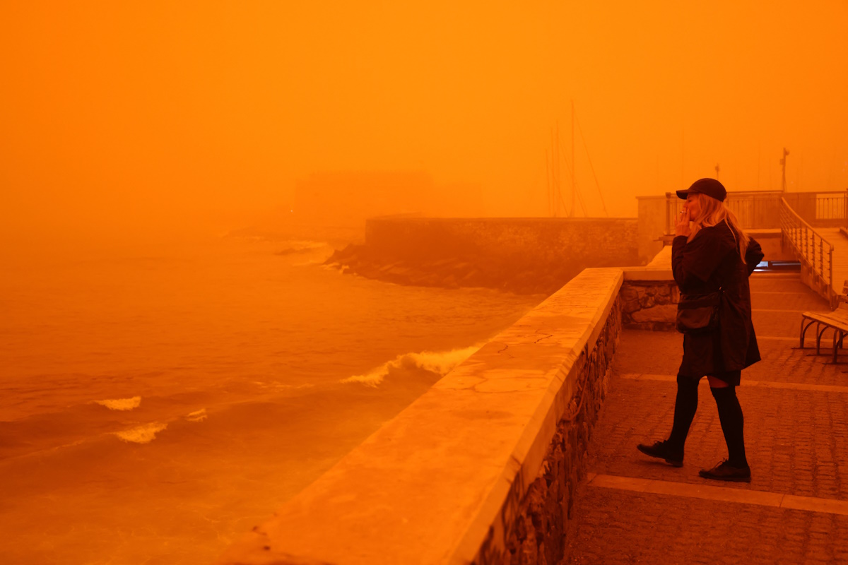A woman walks in the haze caused by sand dust from the Sahara, due to strong southern winds, in Heraklion, Crete island, April 1, 2026. REUTERS