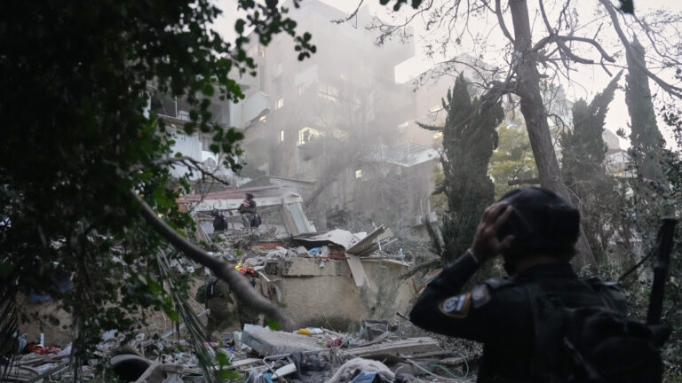 Israeli security forces and rescue teams work amid the rubble of a residential building struck by an Iranian missile in Haifa, Israel, Sunday, April 5, 2026. (AP Photo