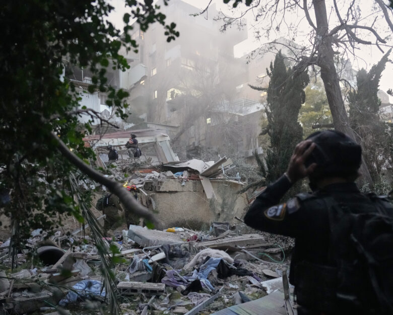 Israeli security forces and rescue teams work amid the rubble of a residential building struck by an Iranian missile in Haifa, Israel, Sunday, April 5, 2026. (AP Photo