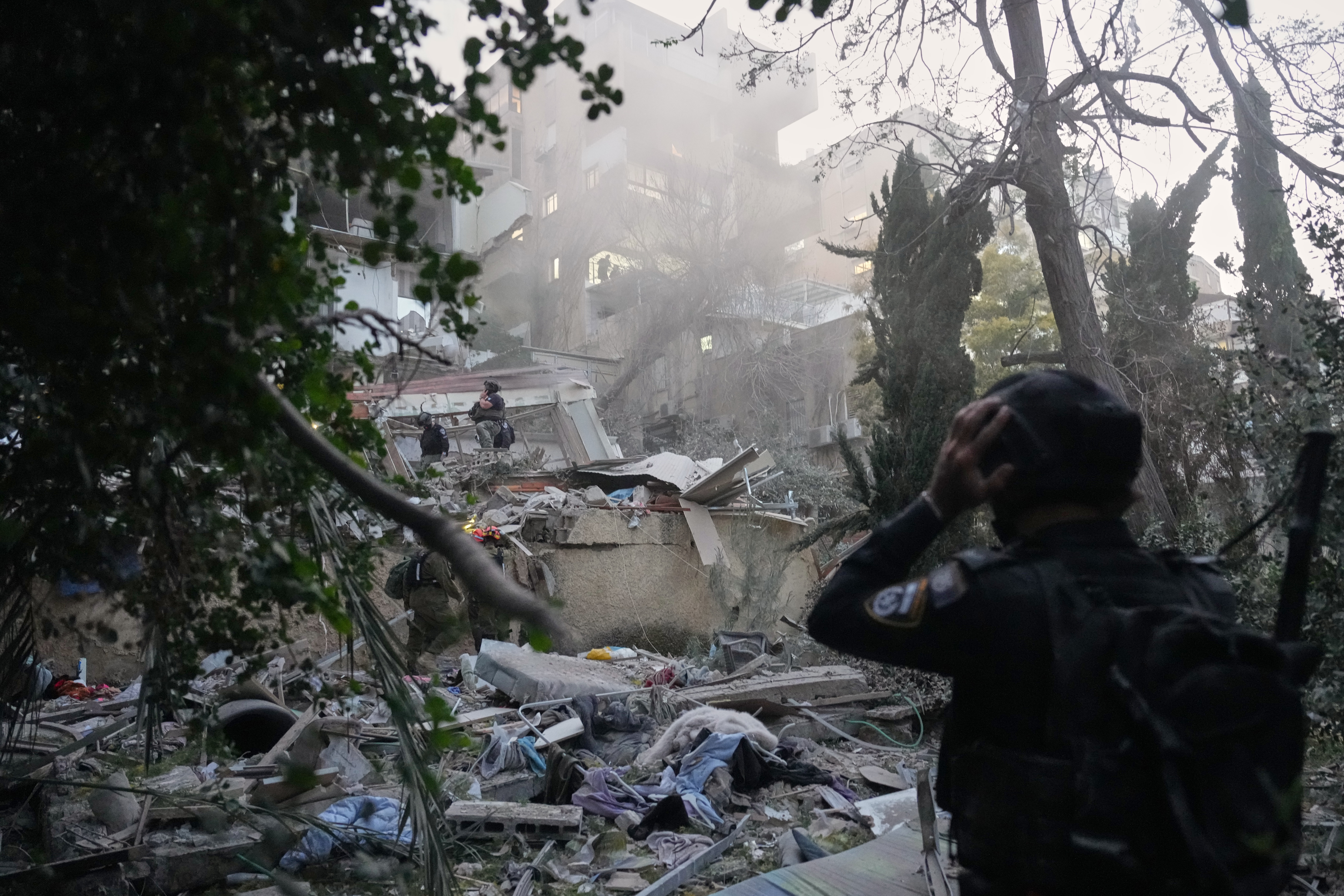 APTOPIX Israel Iran War Israeli security forces and rescue teams work amid the rubble of a residential building struck by an Iranian missile in Haifa, Israel, Sunday, April 5, 2026. (AP Photo/Ariel Schalit)