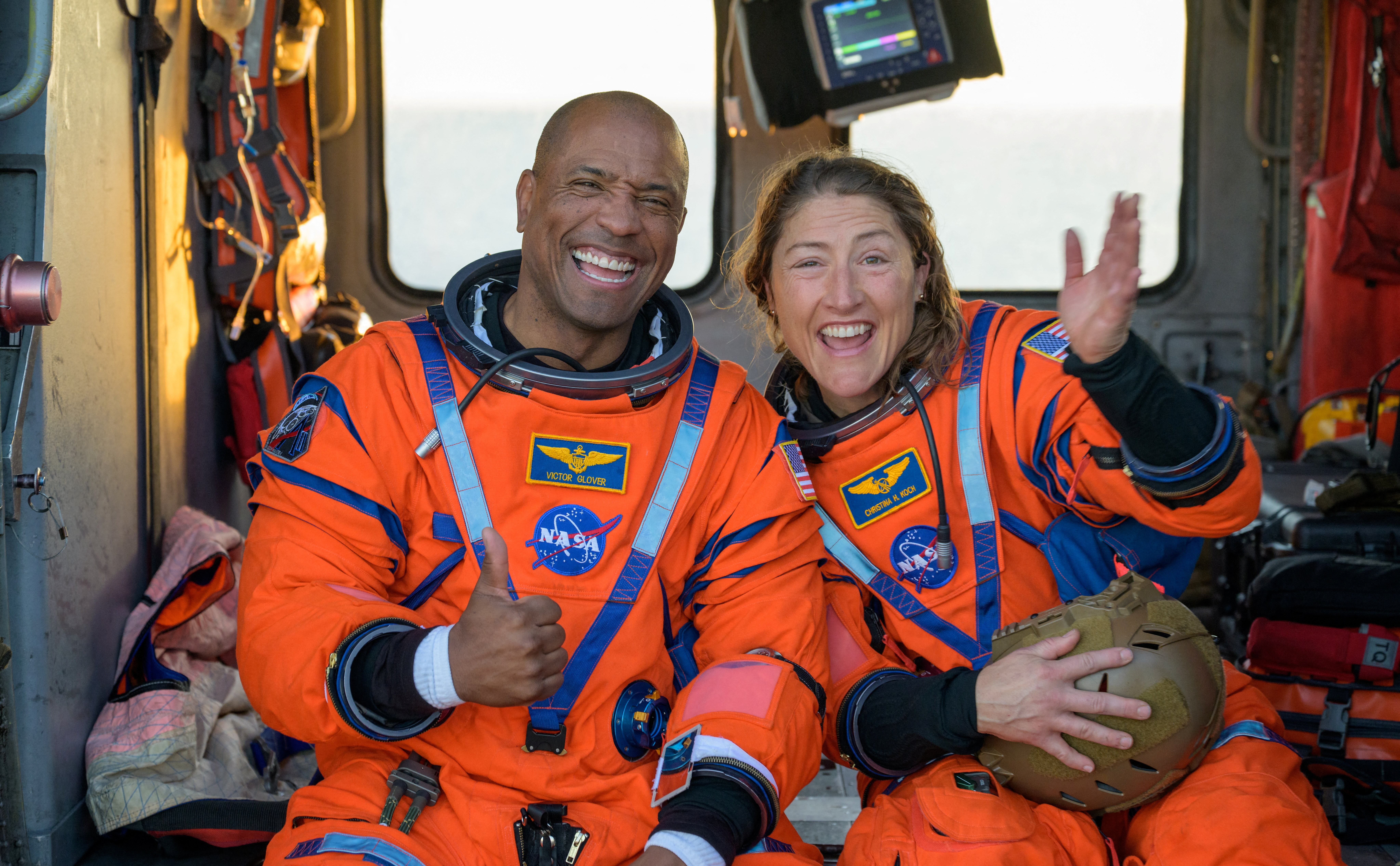 NASA astronaut Victor Glover, Artemis II pilot, and NASA astronaut Christina Koch, Artemis II mission specialist react while sitting on a Navy MH-60 Seahawk from Helicopter Sea Combat Squadron (HSC) 23 on the flight deck of USS John P. Murtha after they and fellow crewmates were extracted from their Orion spacecraft after splashdown, in the Pacific Ocean off the coast of California, U.S. April 10, 2026. NASA
