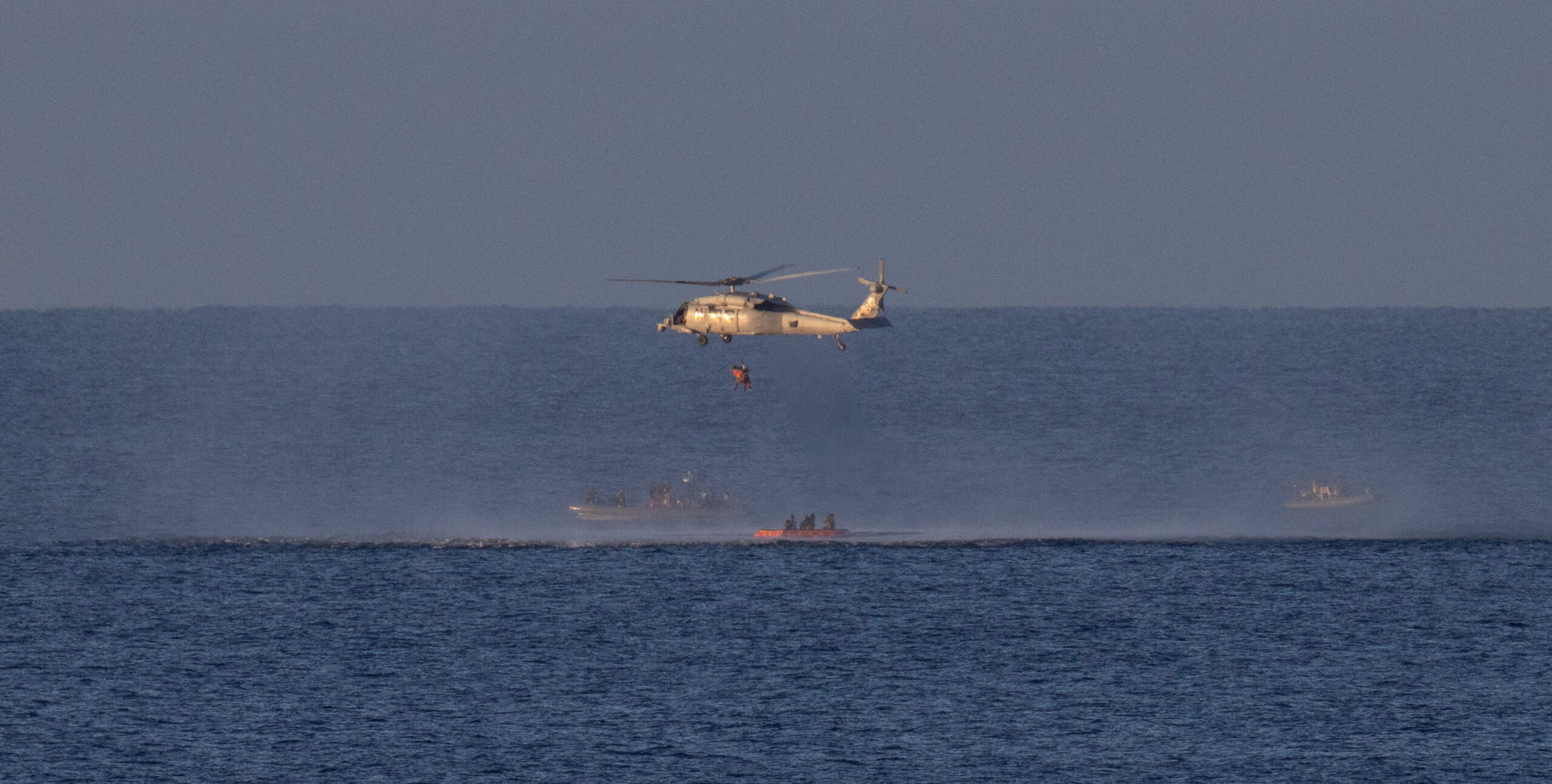 A Navy MH-60 Seahawk from Helicopter Sea Combat Squadron (HSC) 23 lifts NASA astronaut Reid Wiseman, Artemis II commander as teams work to bring the crewmembers aboard USS John P. Murtha, in the Pacific Ocean off the coast of California, April 10, 2026. NASA