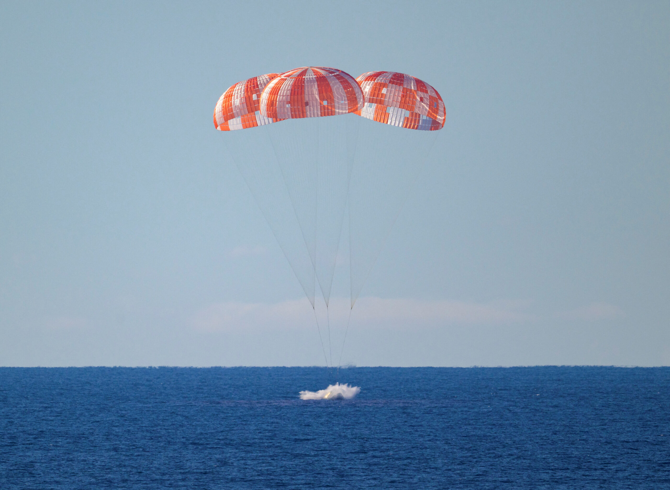 The Artemis II crew capsule under parachutes as it lands during splashdown in the Pacific Ocean off the coast of California, April 10, 2026.  NASA