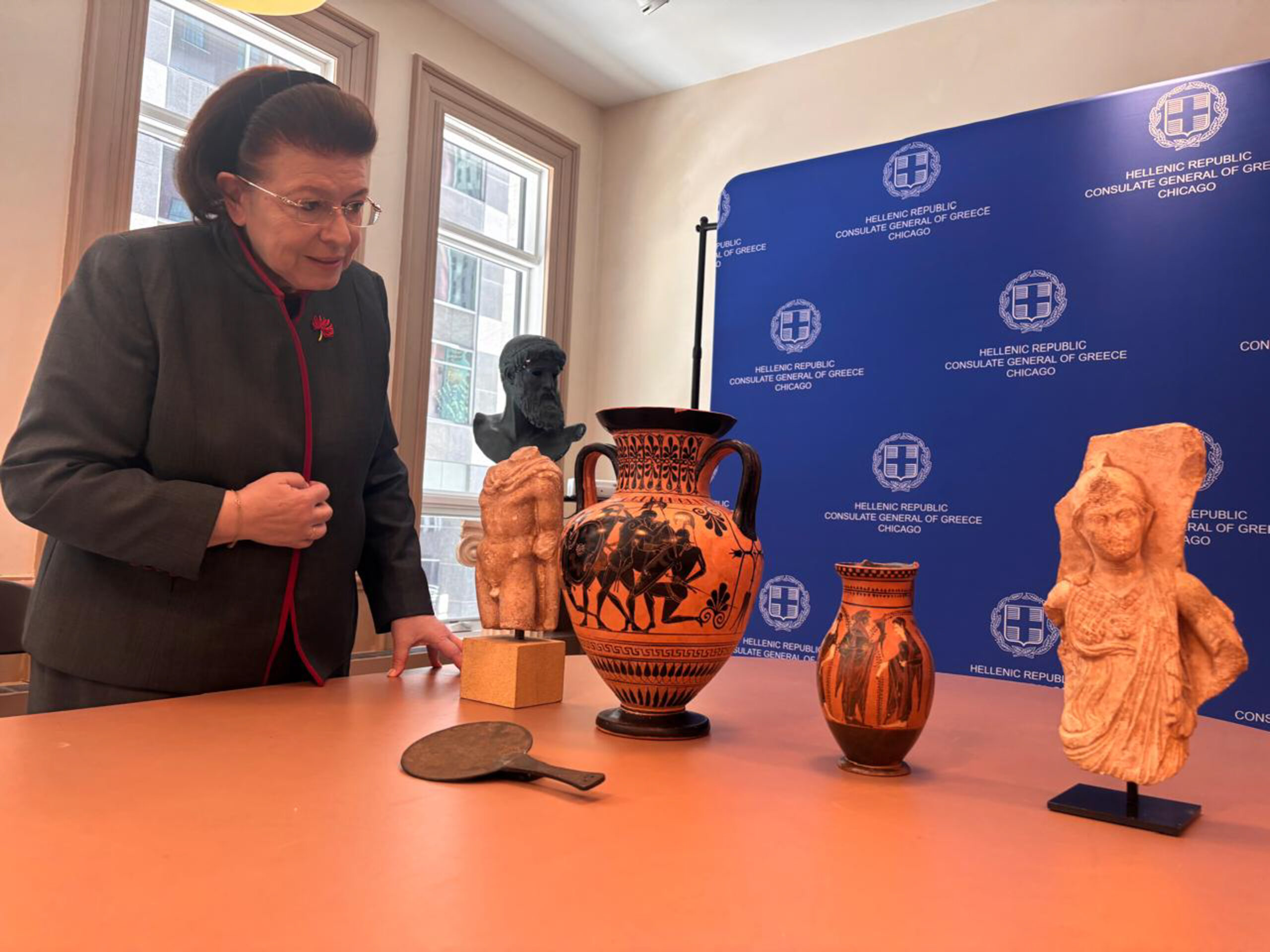 Η Υπουργός Πολιτισμού Λίνα Μενδώνη παρέλαβε, σε ειδική τελετή, στο Γενικό Προξενείο της Ελλάδας, στο Σικάγο, πέντε αρχαιότητες, που επαναπατρίζονται από τις Ηνωμένες Πολιτείες. Πρόκειται για δύο μελανόμορφα αγγεία (αμφορέα και όλπη) αττικών εργαστηρίων του 6ου αιώνα π.Χ. Ένα χάλκινο κάτοπτρο της Ύστερης Αρχαϊκής-Κλασικής περιόδου. Ένα ακέφαλο μαρμάρινο άγαλμα του Ερμή (1ος αι. π.Χ. - 1ος αι. μ.Χ.) και τμήμα αναγλύφου, με παράσταση της θεάς Αθηνάς, του 2ου αι. μ.Χ. Τα αντικείμενα είχαν αποκτηθεί στις δεκαετίες '70 και '80 από την οικογένεια Richard και Mary L. Gray. Τον Μάιο του 2025, τα τρία παιδιά τους, Harry, Jeniffer και Paul Gray, επικοινώνησαν με τις ελληνικές αρχές και προχώρησαν, από κοινού, στην οικειοθελή επιστροφή τους. Η διαδικασία ολοκληρώθηκε, χθες, με ευθύνη της Διεύθυνσης Τεκμηρίωσης και Προστασίας Πολιτιστικών Αγαθών του Υπουργείου Πολιτισμού.  (ΓΡΑΦΕΙΟ ΤΥΠΟΥ ΥΠΟΟΥΡΓΕΙΟΥ ΠΟΛΙΤΙΣΜΟΥ