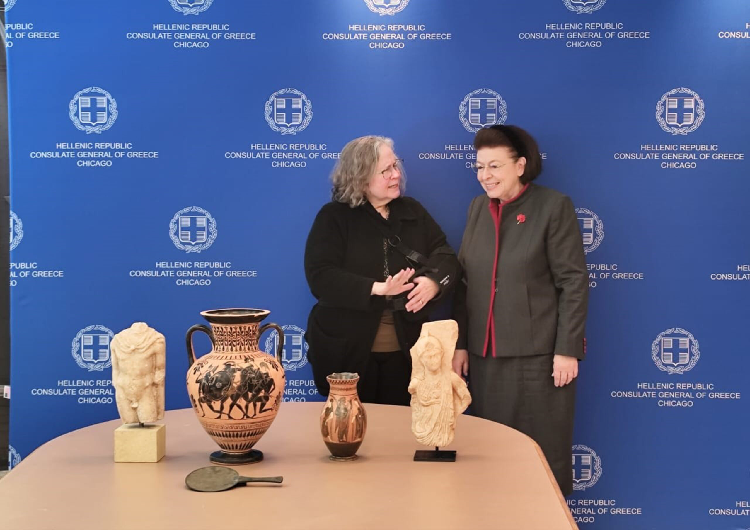 Η Υπουργός Πολιτισμού Λίνα Μενδώνη παρέλαβε, σε ειδική τελετή, στο Γενικό Προξενείο της Ελλάδας, στο Σικάγο, πέντε αρχαιότητες, που επαναπατρίζονται από τις Ηνωμένες Πολιτείες. Πρόκειται για δύο μελανόμορφα αγγεία (αμφορέα και όλπη) αττικών εργαστηρίων του 6ου αιώνα π.Χ. Ένα χάλκινο κάτοπτρο της Ύστερης Αρχαϊκής-Κλασικής περιόδου. Ένα ακέφαλο μαρμάρινο άγαλμα του Ερμή (1ος αι. π.Χ. - 1ος αι. μ.Χ.) και τμήμα αναγλύφου, με παράσταση της θεάς Αθηνάς, του 2ου αι. μ.Χ. Τα αντικείμενα είχαν αποκτηθεί στις δεκαετίες '70 και '80 από την οικογένεια Richard και Mary L. Gray. Τον Μάιο του 2025, τα τρία παιδιά τους, Harry, Jeniffer και Paul Gray, επικοινώνησαν με τις ελληνικές αρχές και προχώρησαν, από κοινού, στην οικειοθελή επιστροφή τους. Η διαδικασία ολοκληρώθηκε, χθες, με ευθύνη της Διεύθυνσης Τεκμηρίωσης και Προστασίας Πολιτιστικών Αγαθών του Υπουργείου Πολιτισμού.  (ΓΡΑΦΕΙΟ ΤΥΠΟΥ ΥΠΟΟΥΡΓΕΙΟΥ ΠΟΛΙΤΙΣΜΟΥ