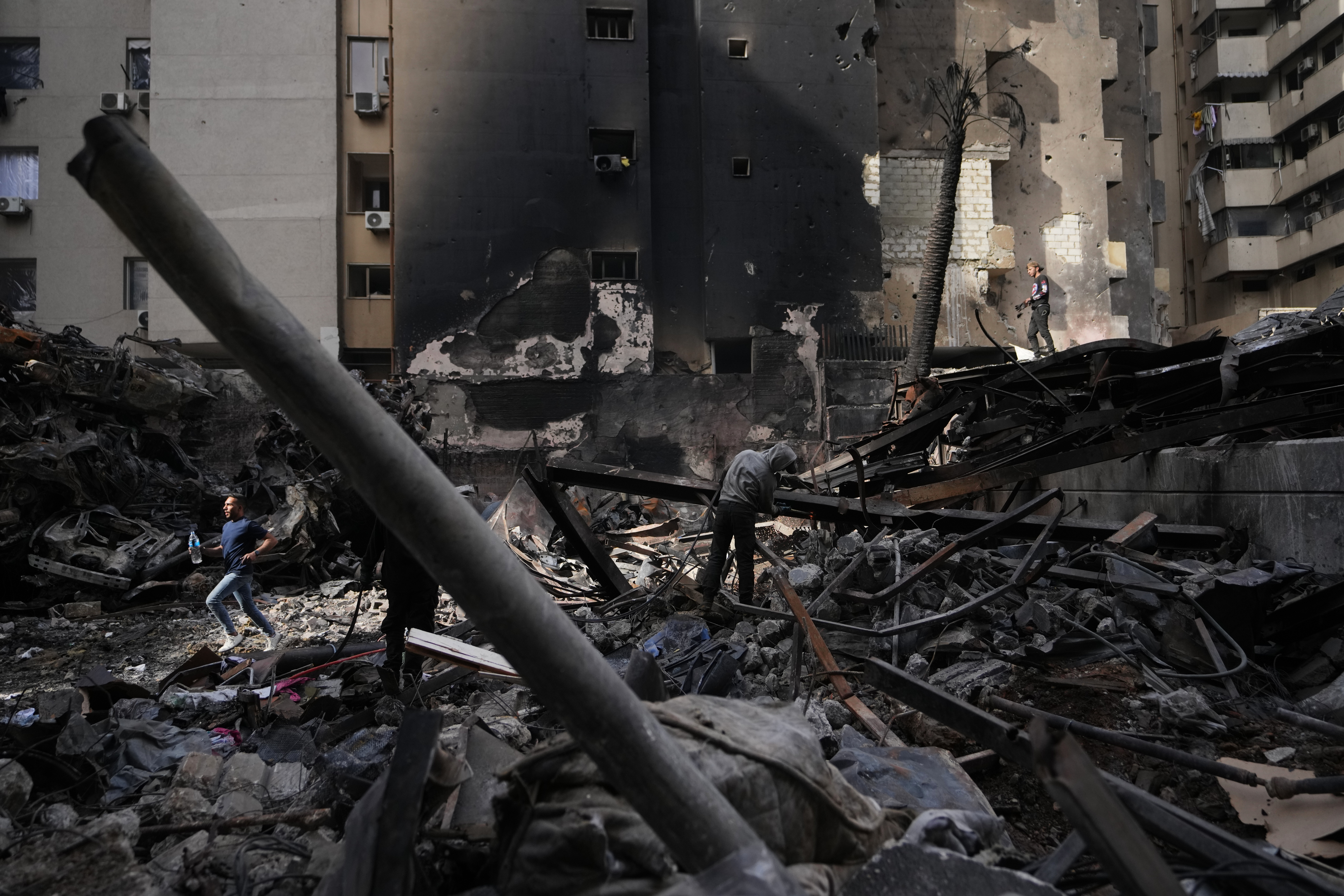 Lebanon Israel Iran War A resident moves through debris as others collect scrap metal at the site of a building destroyed in an Israeli airstrike last Wednesday in central Beirut, Lebanon, Tuesday, April 14, 2026. (AP Photo/Hassan Ammar)