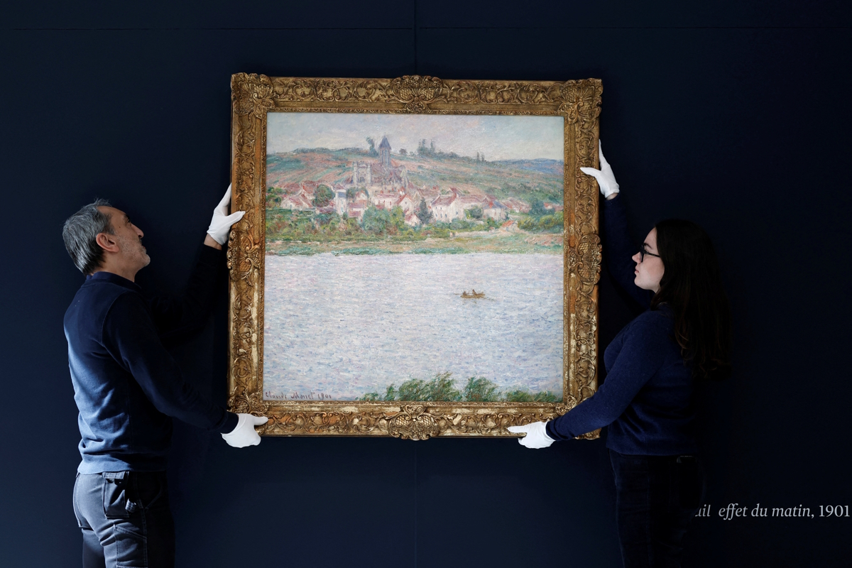 Υπάλληλοι του οίκου δημοπρασιών Sotheby’s με τον πίνακα «Vetheuil, Effet du Matin (1901)» του Γάλλου ιμπρεσιονιστή ζωγράφου Κλοντ Μονέ