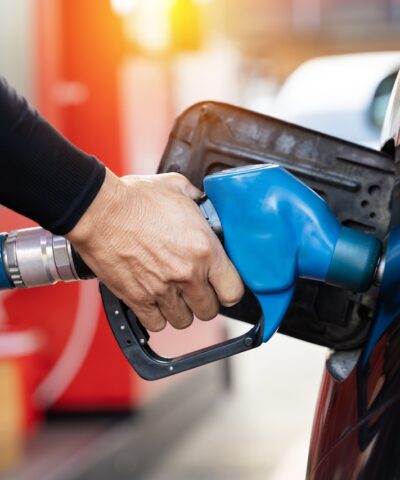 Refueling the car at a gas station fuel pump. Man driver hand refilling and pumping gasoline oil the car with fuel at he refuel station. Car refueling on petrol station. Fuel pump at station