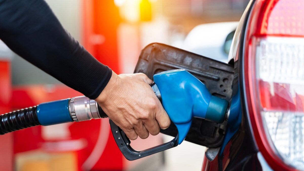 Refueling the car at a gas station fuel pump. Man driver hand refilling and pumping gasoline oil the car with fuel at he refuel station. Car refueling on petrol station. Fuel pump at station