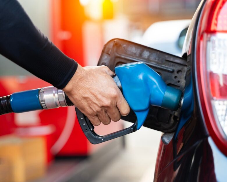 Refueling the car at a gas station fuel pump. Man driver hand refilling and pumping gasoline oil the car with fuel at he refuel station. Car refueling on petrol station. Fuel pump at station