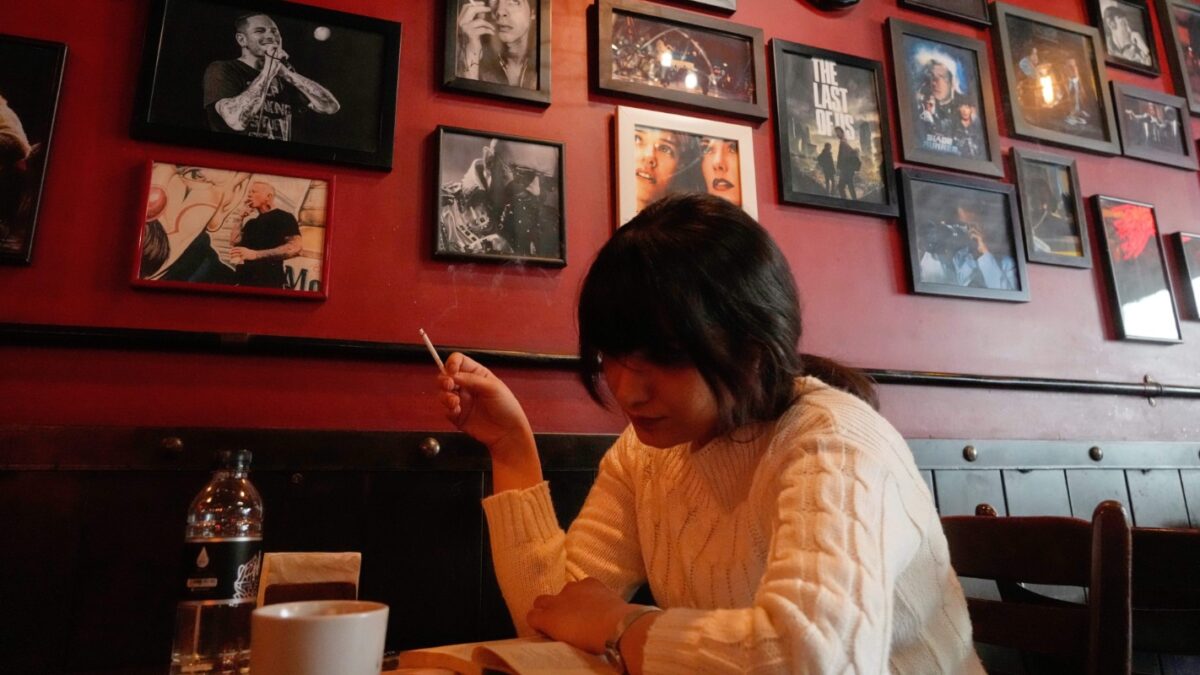 A woman sits at a cafe decorated with images of western celebrities, in Tehran, Iran, Tuesday, Feb. 17, 2026. (AP Photo/Vahid Salemi)