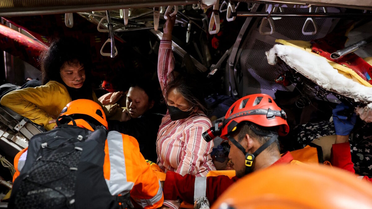 Μέλη των ομάδων έκτακτης ανάγκης διασώζουν θύματα που έχουν παγιδευτεί στο κατεστραμμένο τρένο στην Ινδονησία