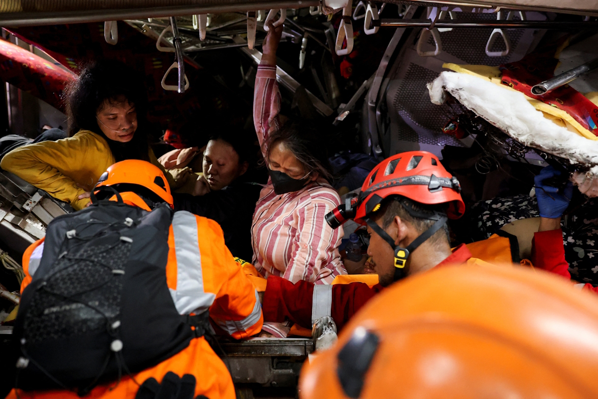Μέλη των ομάδων έκτακτης ανάγκης διασώζουν θύματα που έχουν παγιδευτεί στο κατεστραμμένο τρένο στην Ινδονησία