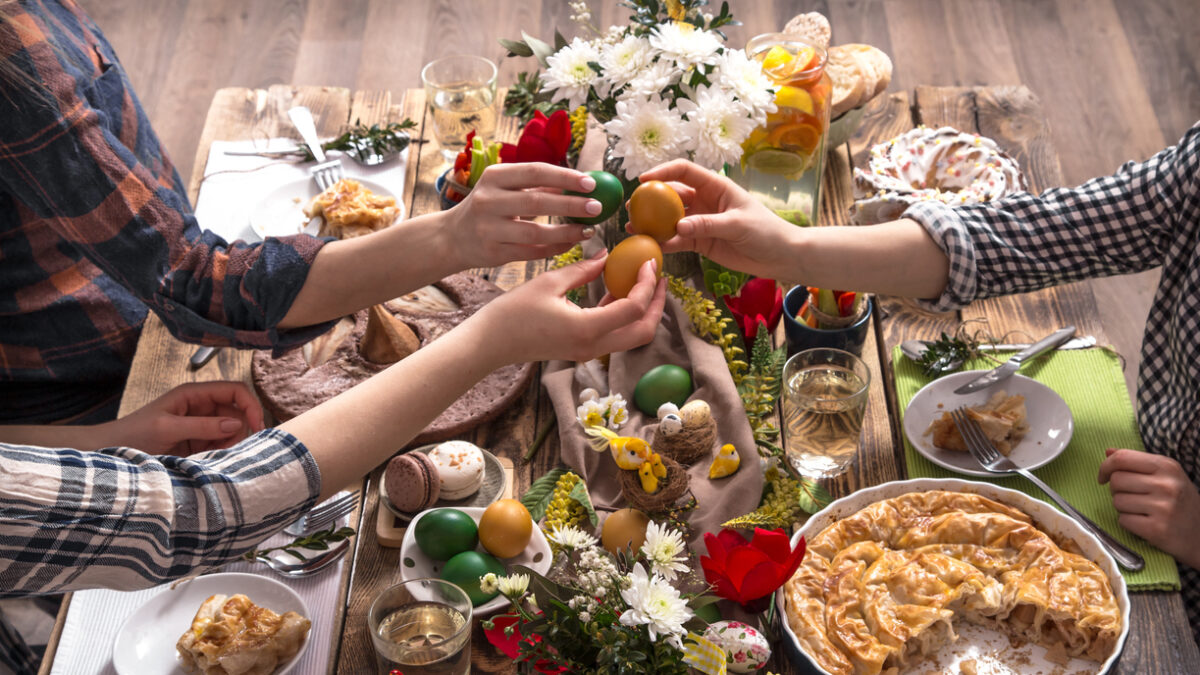 Home Holiday friends or family at the festive Easter table with Easter colored eggs. The concept of the celebration