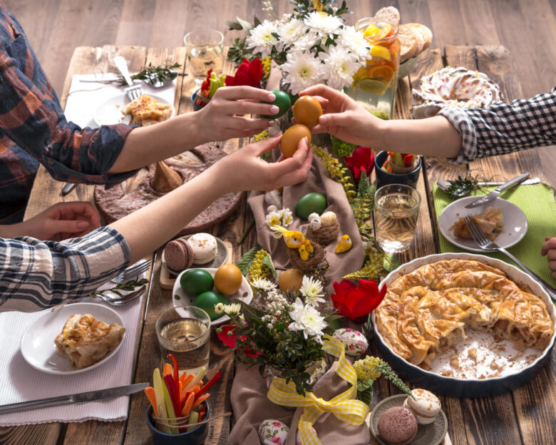 Home Holiday friends or family at the festive Easter table with Easter colored eggs. The concept of the celebration