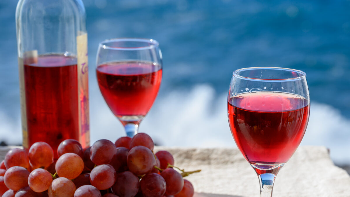 Two glasses of cold rose wine served outdoor with pink grapes