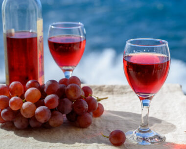 Two glasses of cold rose wine served outdoor with pink grapes
