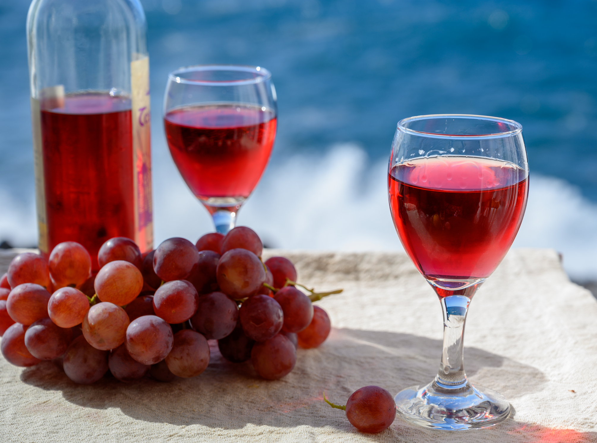 Two glasses of cold rose wine served outdoor with pink grapes