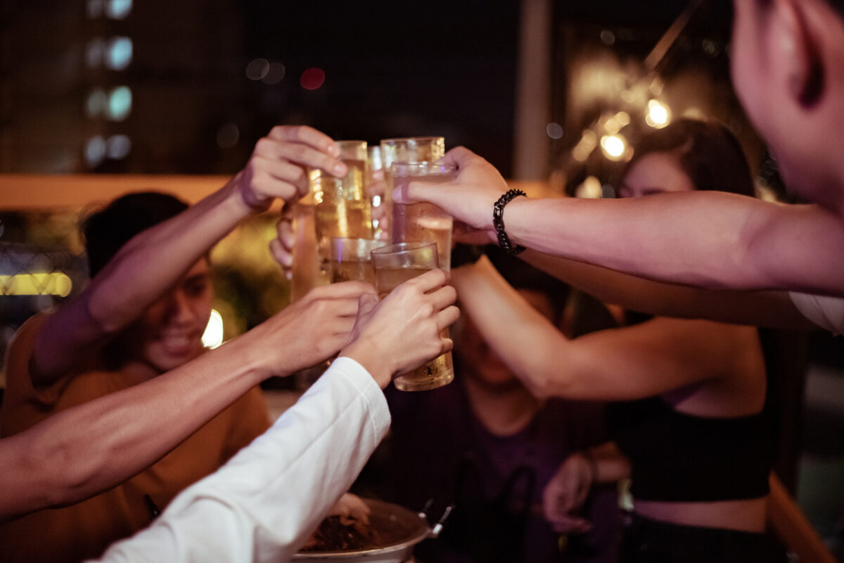 Group of young people hands toasting and cheering aperitif beers