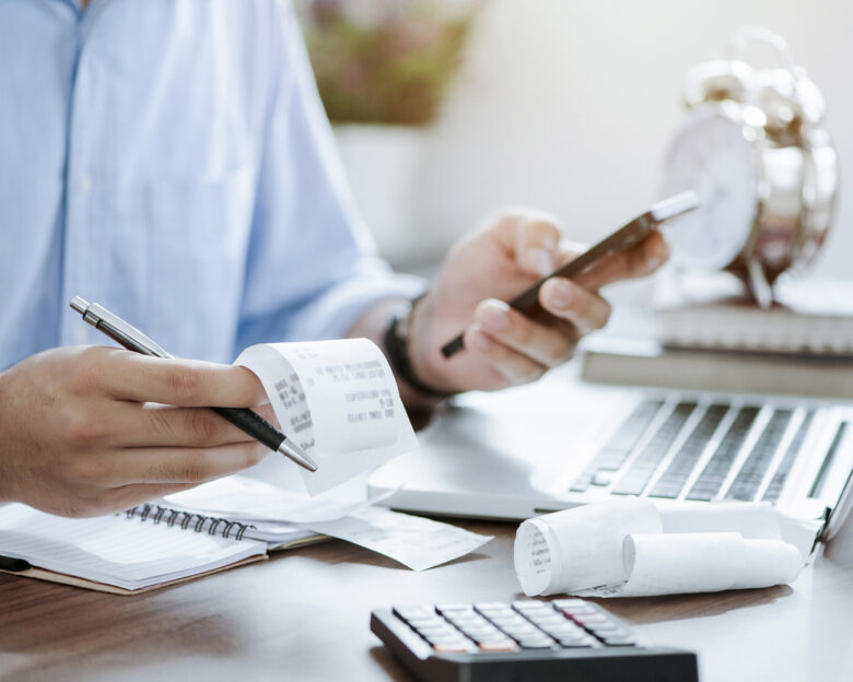 young man holding pen with bills working for calculate business data, taxes, bills payment, Start up counting finance. accounting, statistics, and analytic research concept
