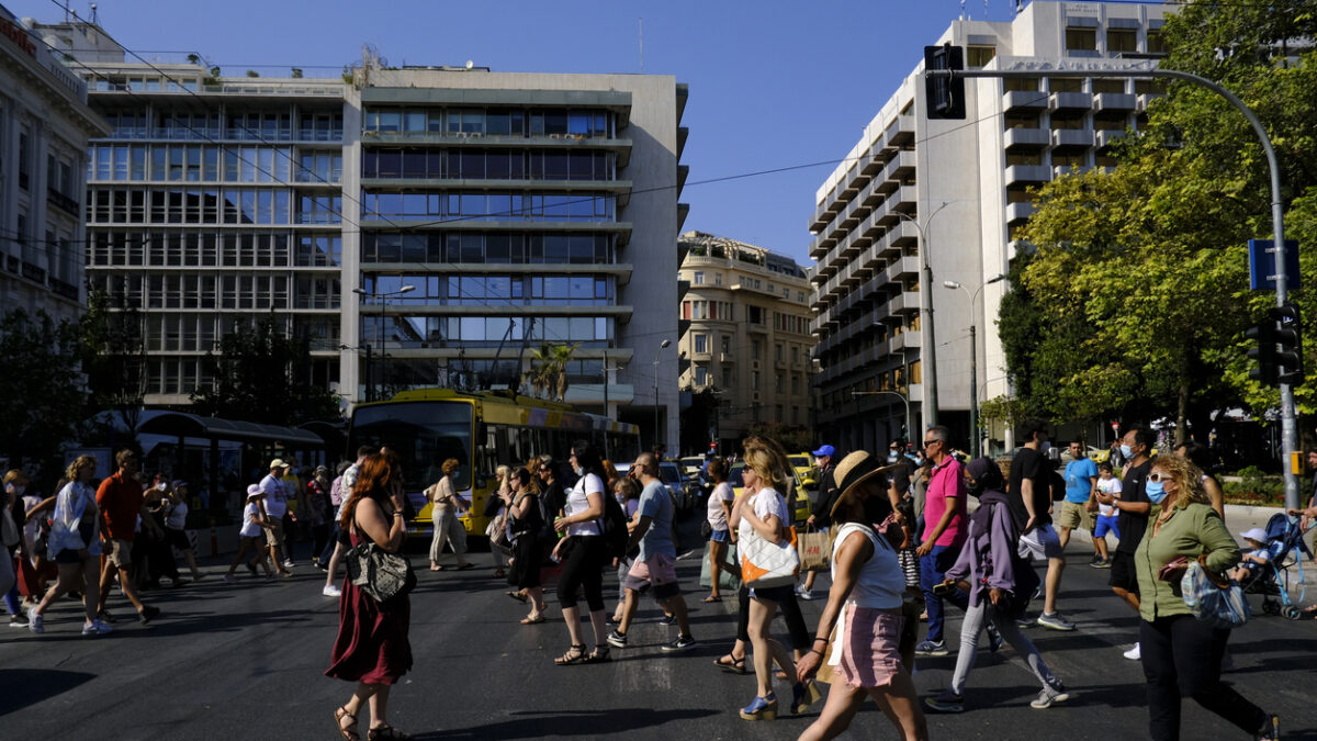 Crowd of people pass from pedestrians line during a hot day in central Athens, Greece
