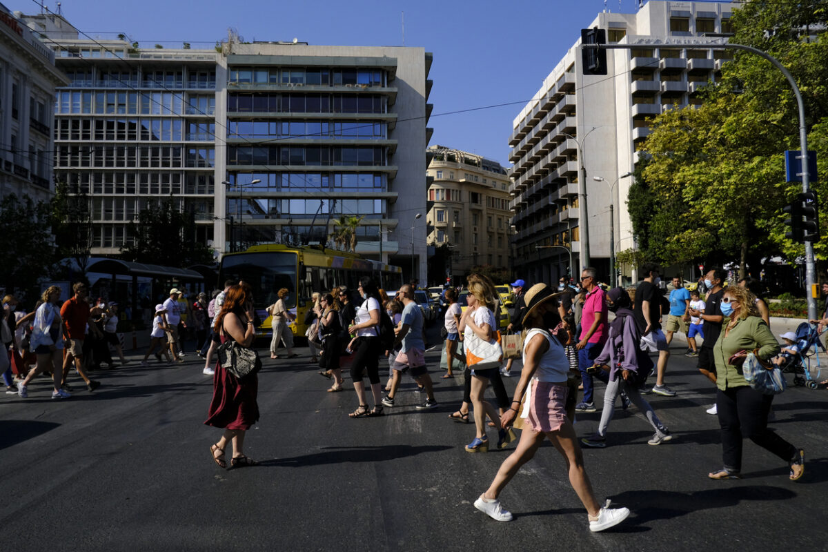 Crowd of people pass from pedestrians line during a hot day in central Athens, Greece