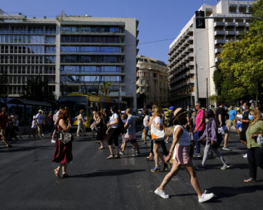 Crowd of people pass from pedestrians line during a hot day in central Athens, Greece