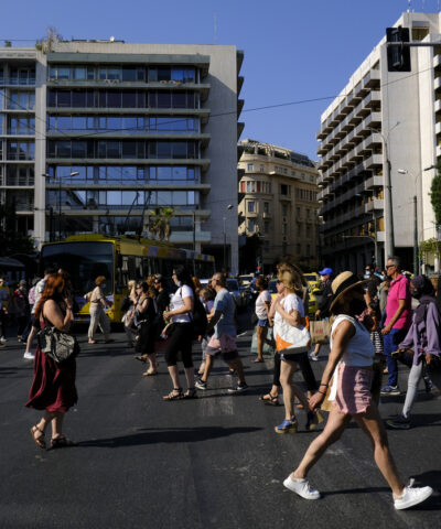 Crowd of people pass from pedestrians line during a hot day in central Athens, Greece