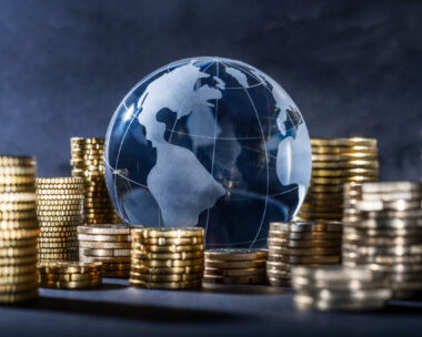 Globe and stack with coins. Money makes the world go round