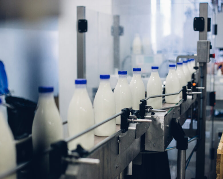 A selective focus shot of complete milk bottling line in a factory
