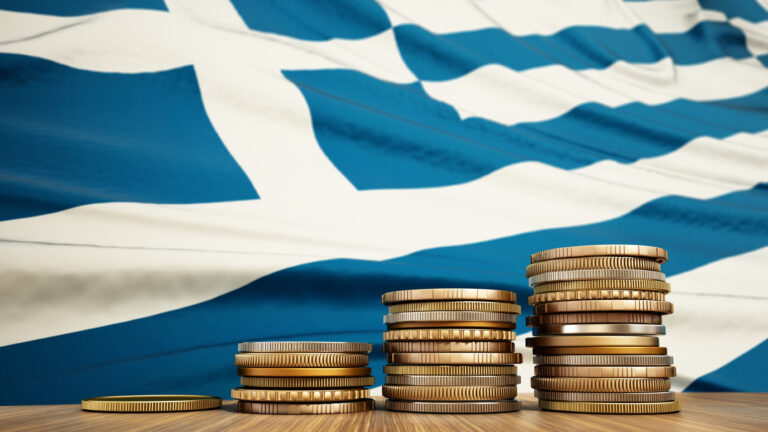 Rising stack of coins with Greek flag in the background. Economy, finance, interest rates concept.