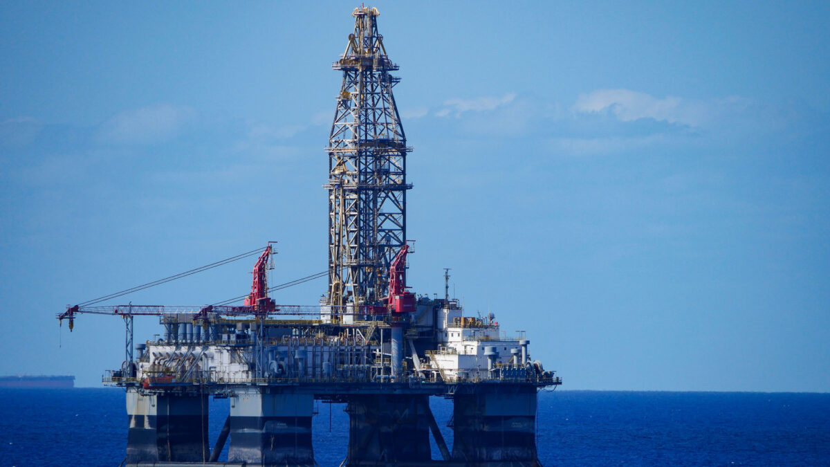 A large offshore oil rig in the middle of a vast expanse of ocean