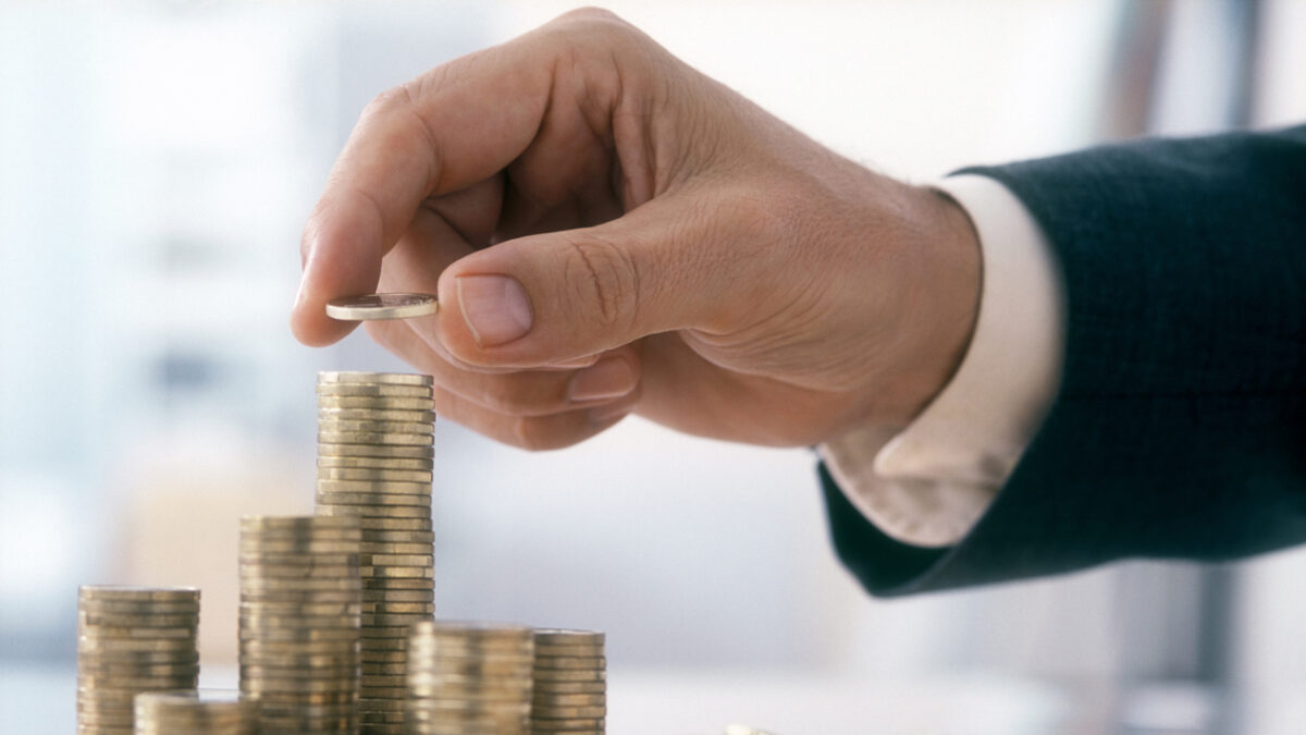 Hand of a mid adult man, wearing a siut, is stacking Euro coins. (2XL-File)