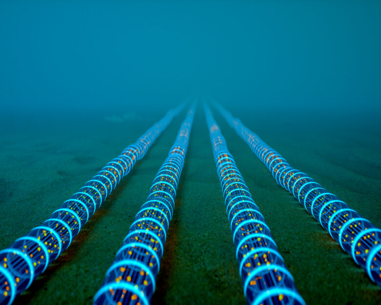 High-tech fiber optic cables glowing with blue light extend into the distance on the ocean floor, symbolizing global communication networks.
