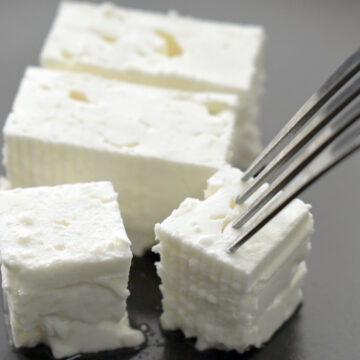 Feta cheese with fork on a plate. Traditional Greek food.