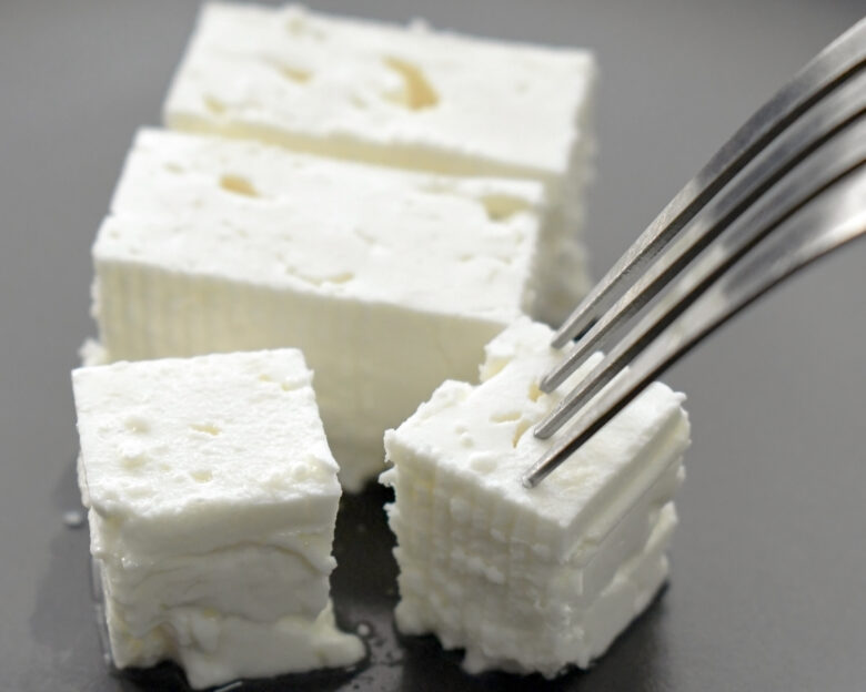 Feta cheese with fork on a plate. Traditional Greek food.
