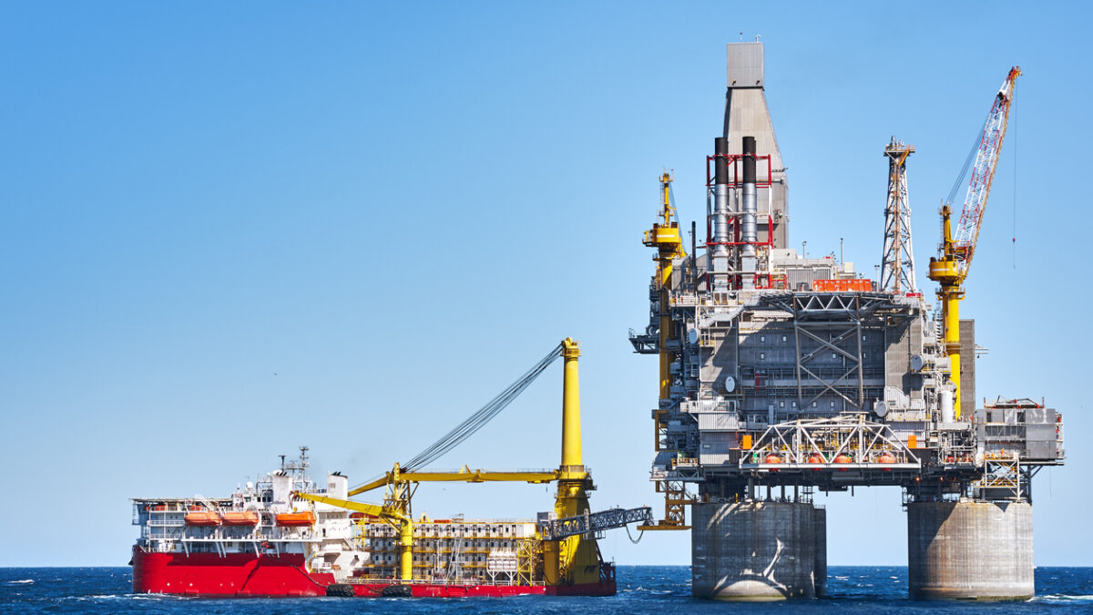 Oil rig and support vessel on offshore area near Sakhalin island. Blue sky background