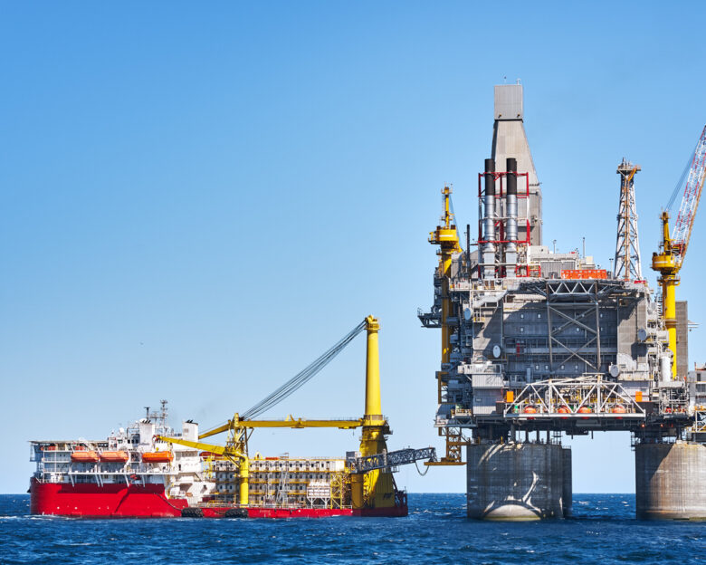 Oil rig and support vessel on offshore area near Sakhalin island. Blue sky background