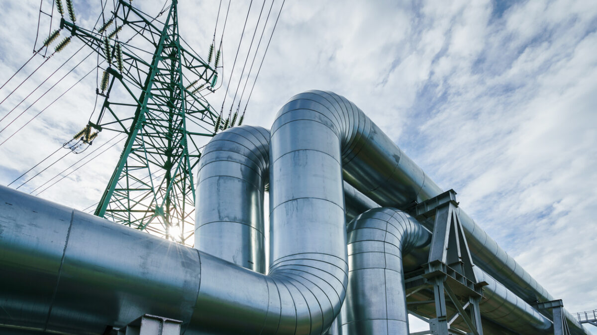 Industrial pipelines on pipe-bridge against blue sky