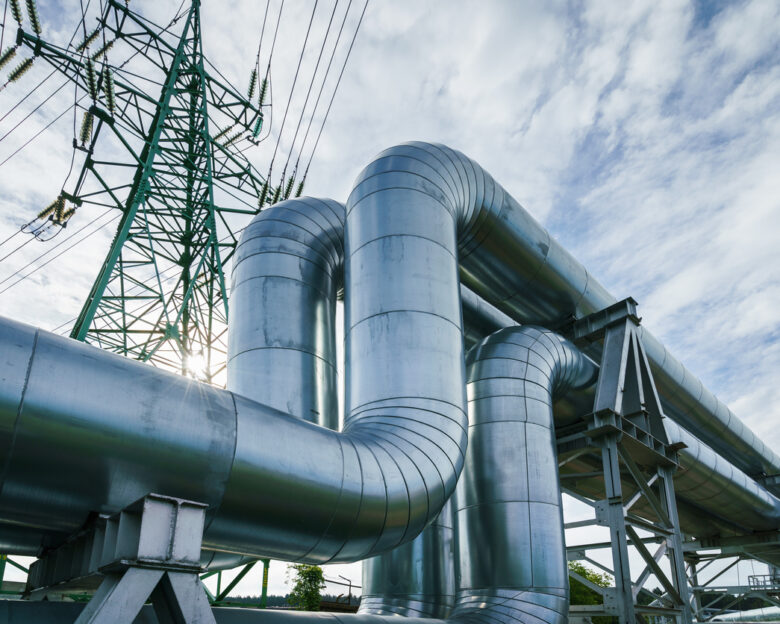 Industrial pipelines on pipe-bridge against blue sky