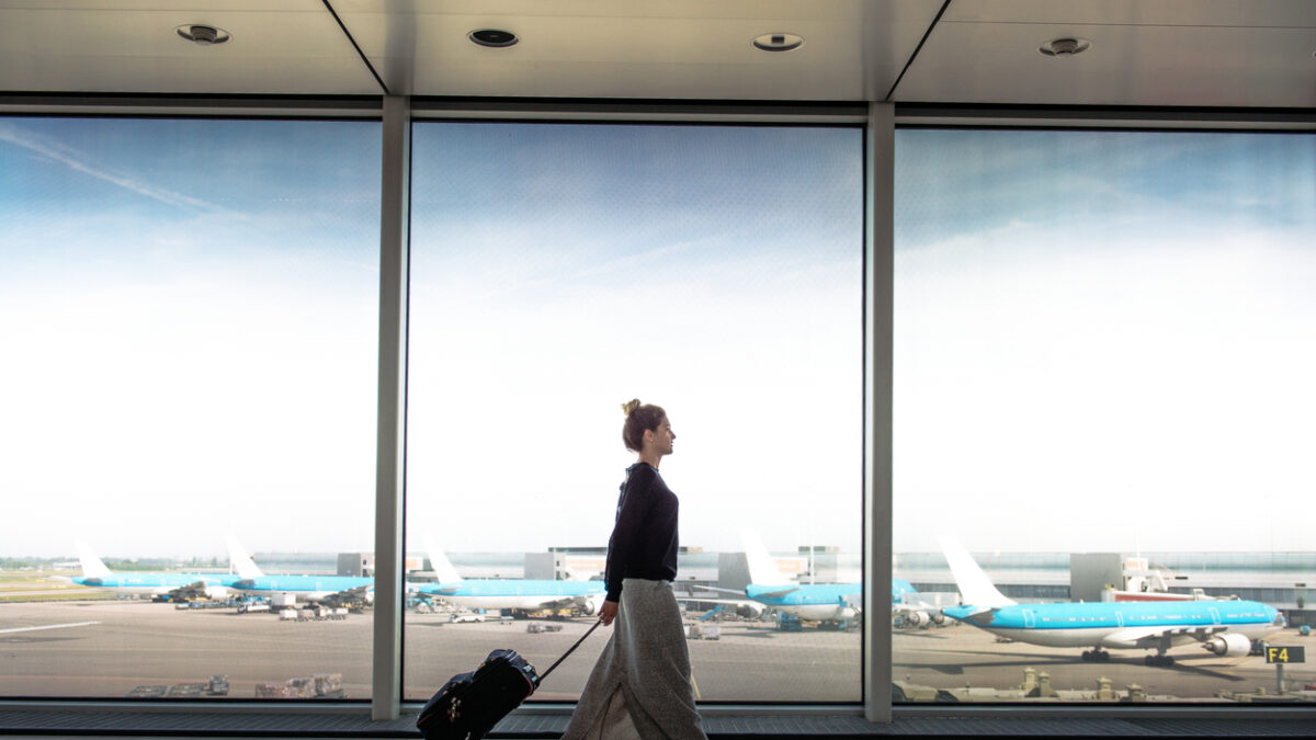 Woman with suitcase rushing to the check in for the flight at the airport