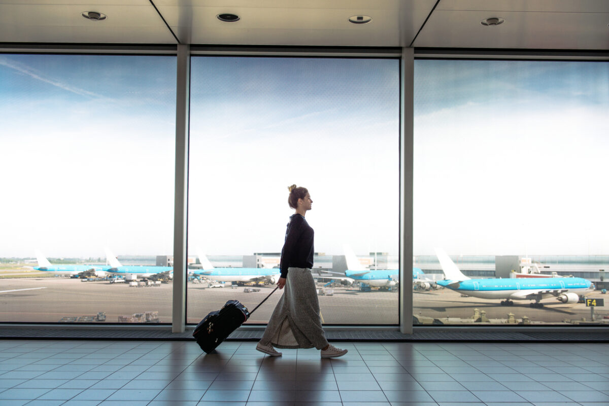 Woman with suitcase rushing to the check in for the flight at the airport