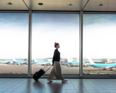 Woman with suitcase rushing to the check in for the flight at the airport