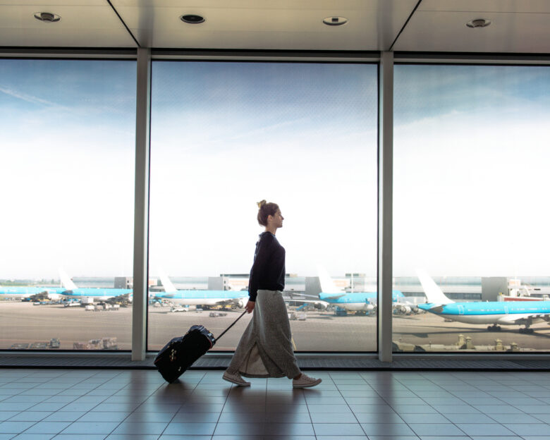 Woman with suitcase rushing to the check in for the flight at the airport