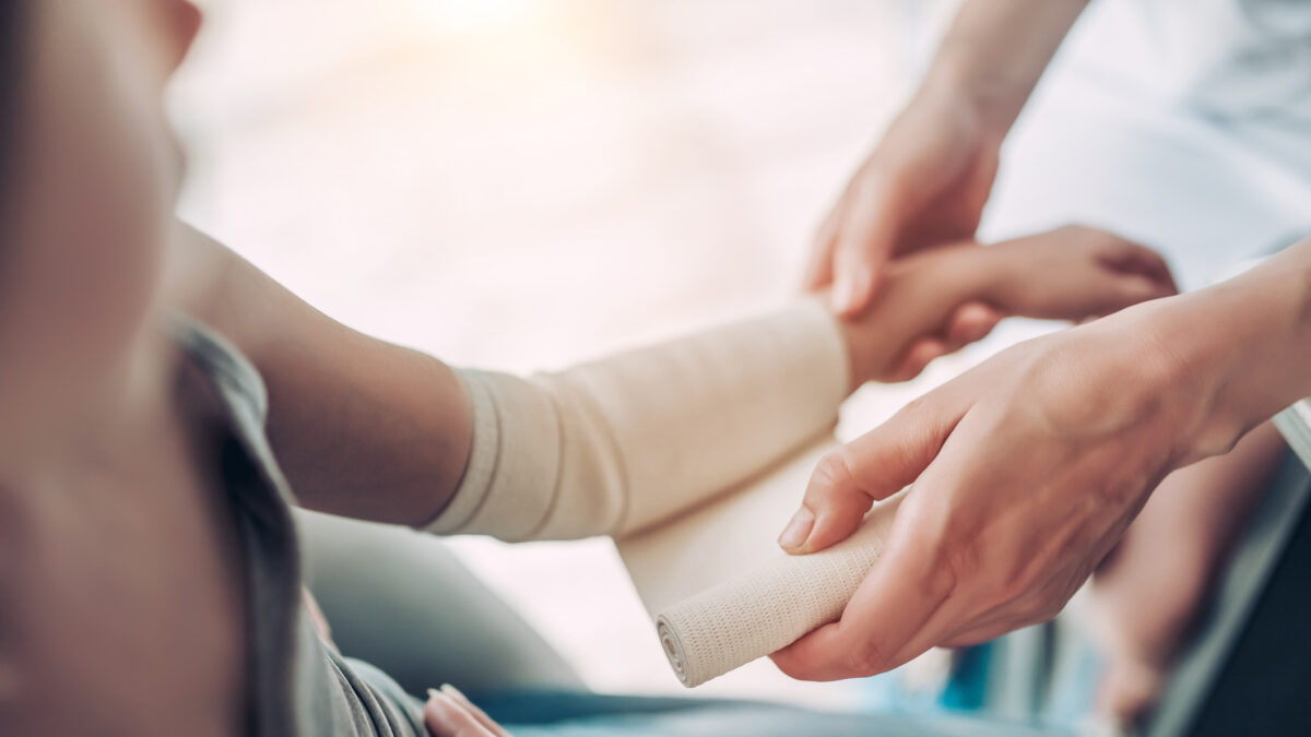 Cute little girl with mother at the doctor pediatrician. Using bandage for hand injury.