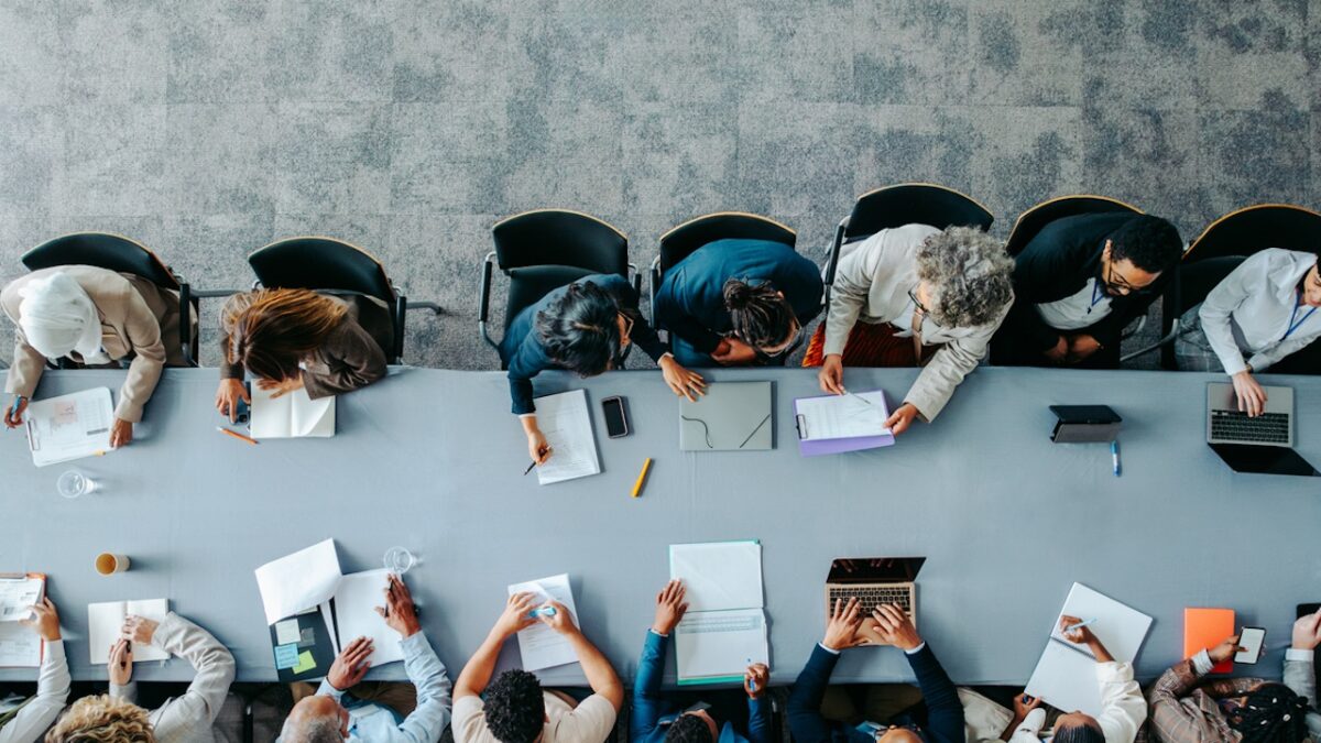Top view of diverse business group in office meeting, collaborating and discussing around a large table.