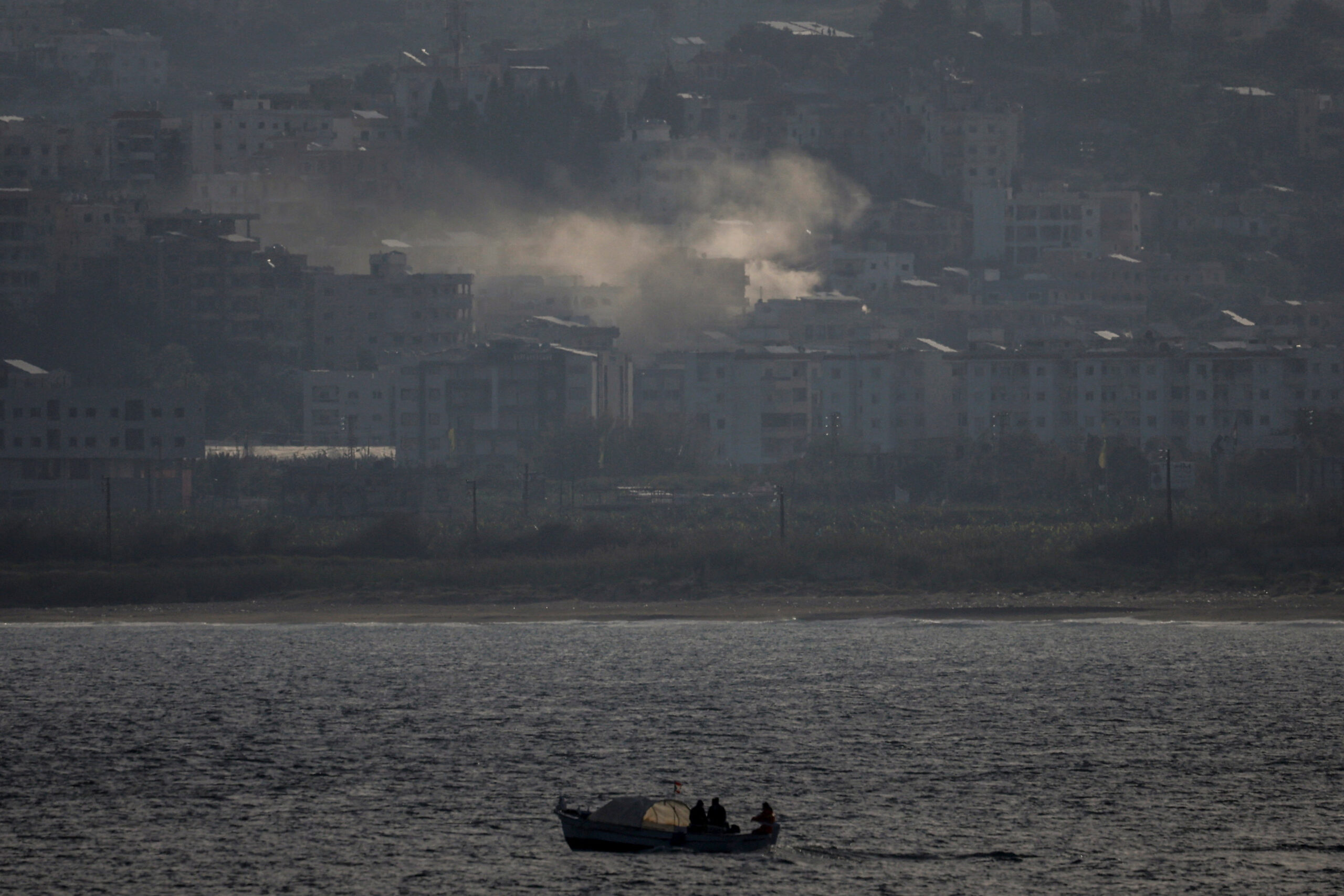 Smoke from an airstrike is seen in Tyre Fishermen sail their boat as smoke from an airstrike rises in Abbassiye area in Tyre, Lebanon, April 14, 2026. REUTERS/Louisa Gouliamaki