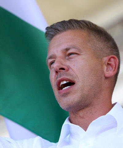 FILE PHOTO: Peter Magyar, leader of the opposition Tisza party, waves a Hungarian flag at a rally near the venue of ruling Fidesz party closed doors meeting where Prime Minister Viktor Orban discusses campaign issues with party officials in Kotcse, Hungary September 7, 2025. REUTERS/Bernadett Szabo/File Photo