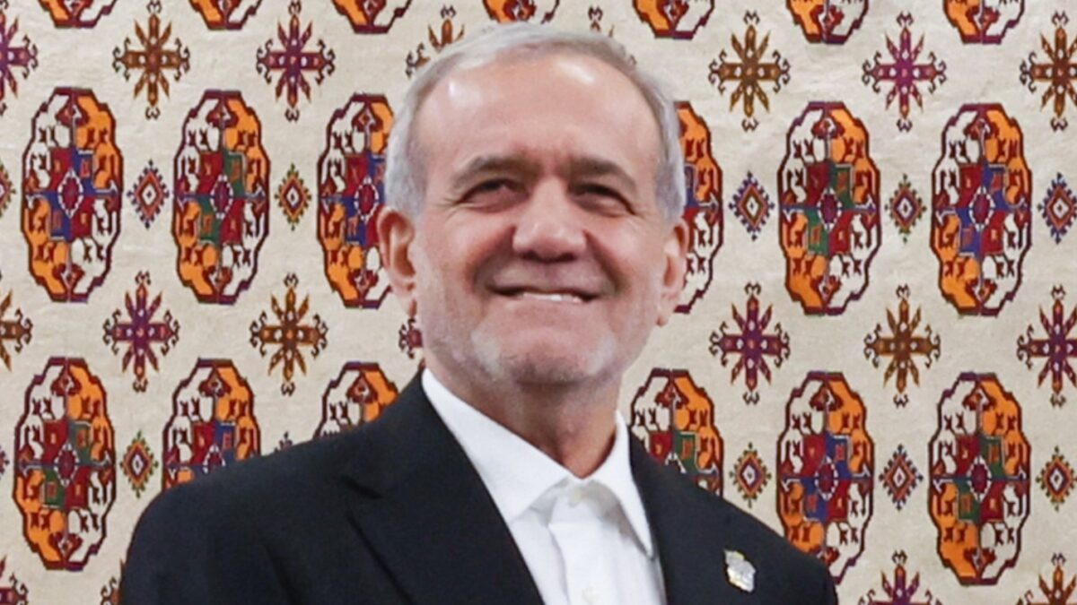 In this photo released by the Iranian Presidency Office, President Masoud Pezeshkian, left, shakes hands with his Russian counterpart Vladimir Putin during their meeting on the sidelines of an international forum in Ashgabat, Turkmenistan, Friday, Dec. 12, 2025. (Iranian Presidency Office via AP)